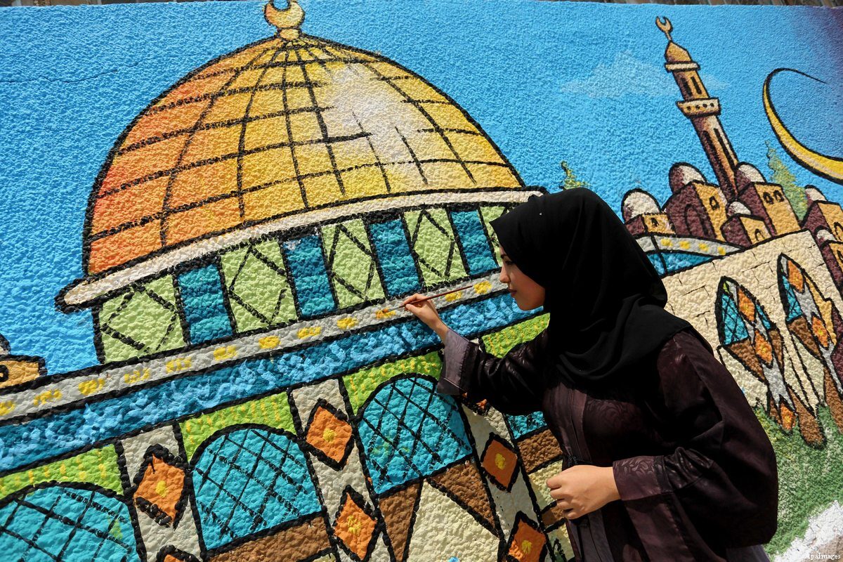 A Palestinian artist paints a mural depicting the Dome of the Rock in Gaza city on July 25, 2017 [Ashraf Amra / Apa Images]