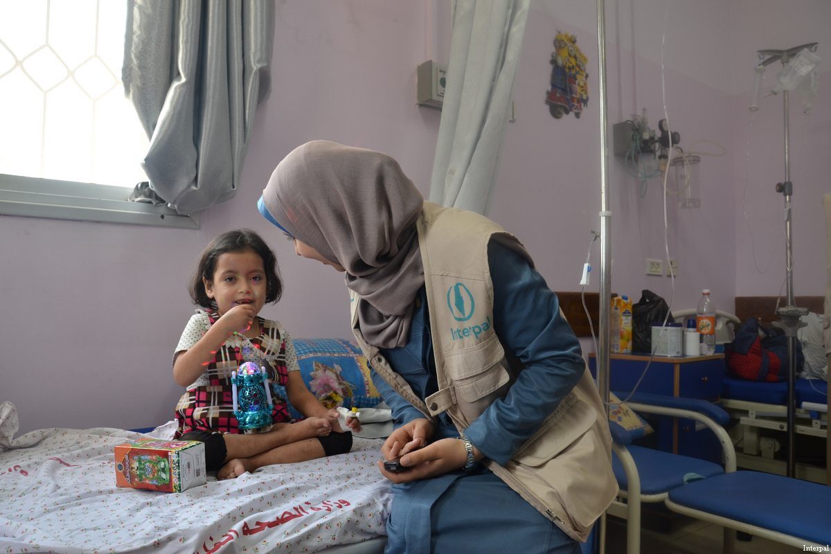 An Interpal aid worker seen with a Palestinian child in hospital