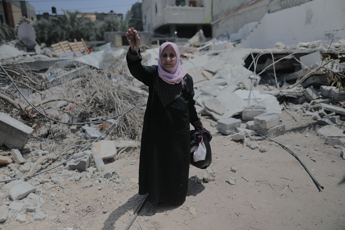 Interpal - Gaza old lady stands in rubble