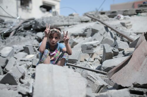 A girl in Gaza sits amongst the rubble of a building bombed by Israel. Photo published 14 Aug 2022 [Mohammed Ibrahim / Unsplash]