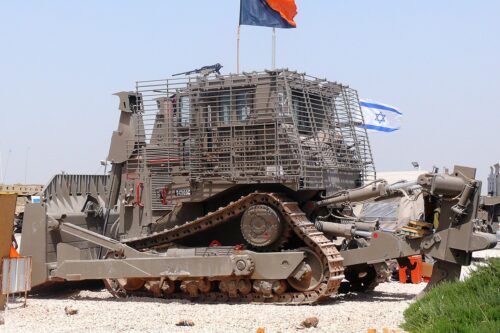 An Israeli Caterpillar D9R armoured bulldozer, flying the orange-black flag of the IDF Combat Engineering Corps, next to its roof-mounted machine gun, seen on April 20, 2010 [zachievenor / Flickr]